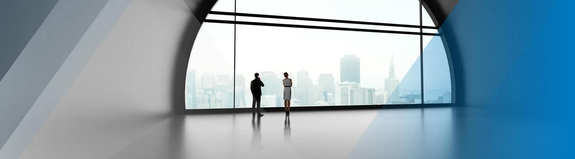 Two people in a large open space looking over a city skyline
