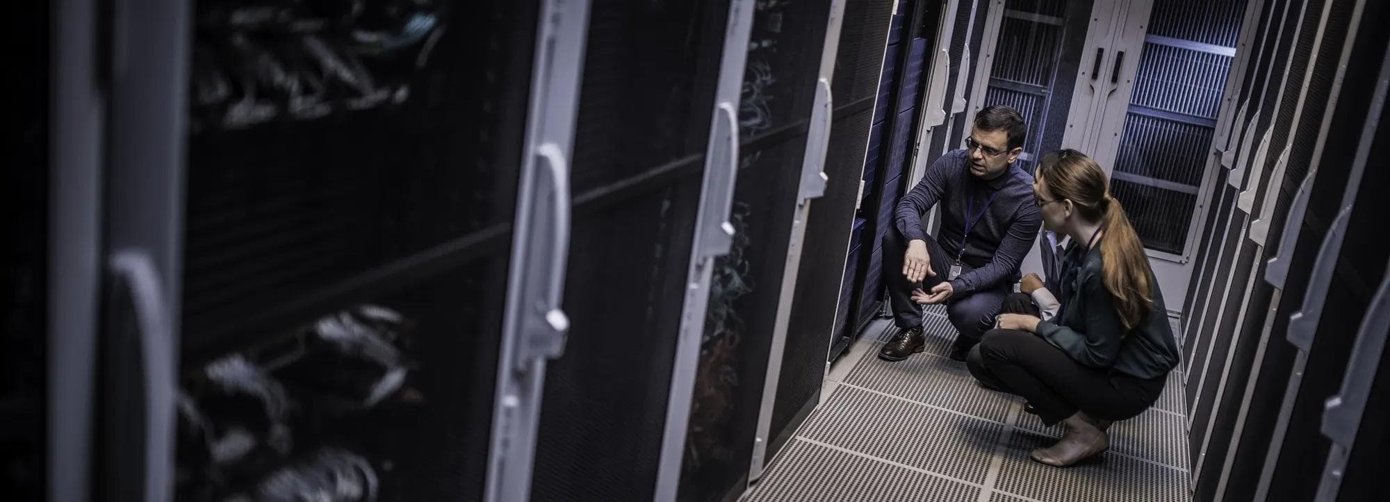 A technician explains server functioning in a data center room. 