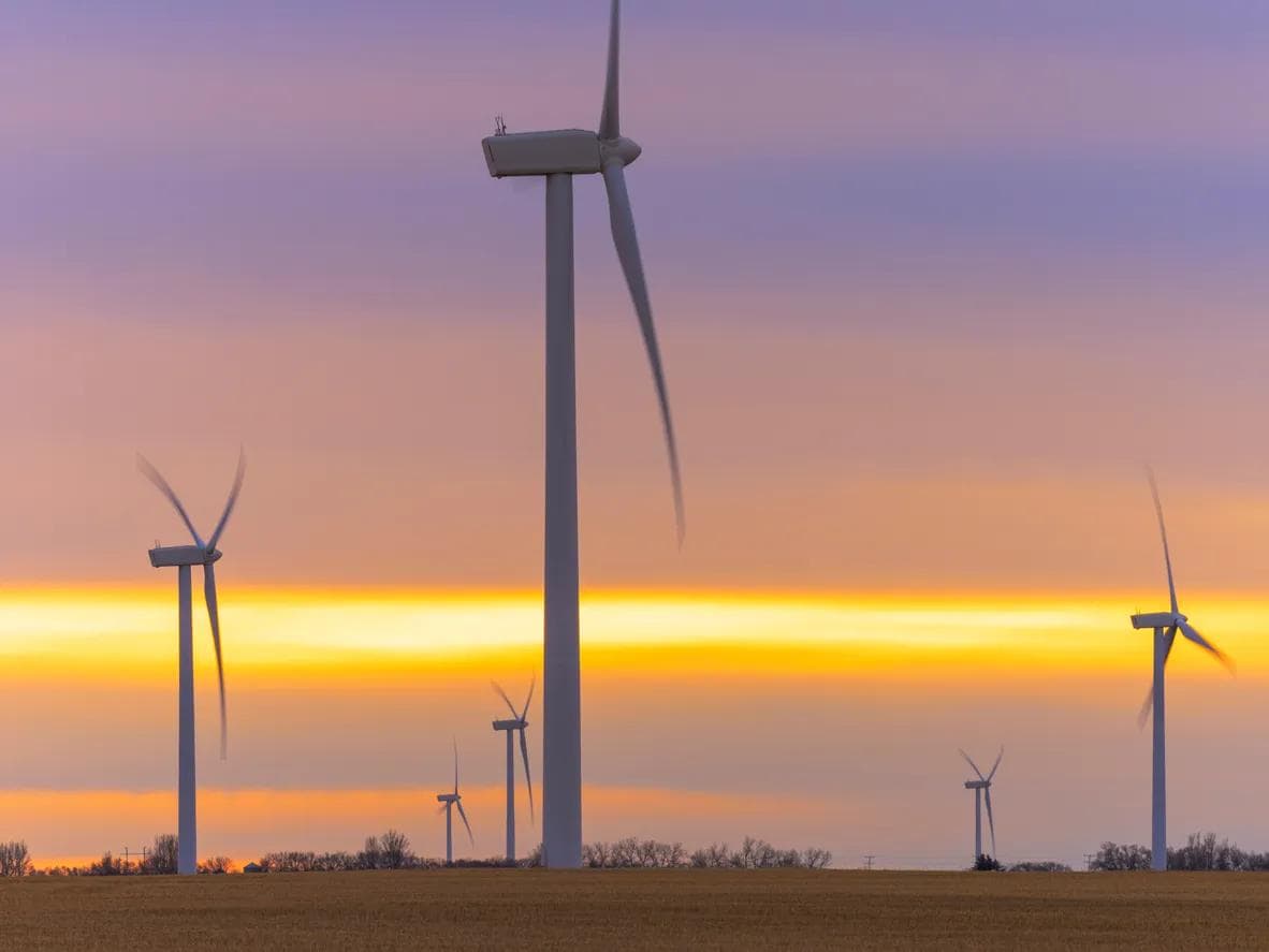 Wind turbines spin at sunrise in Saskatchewan, Canada.