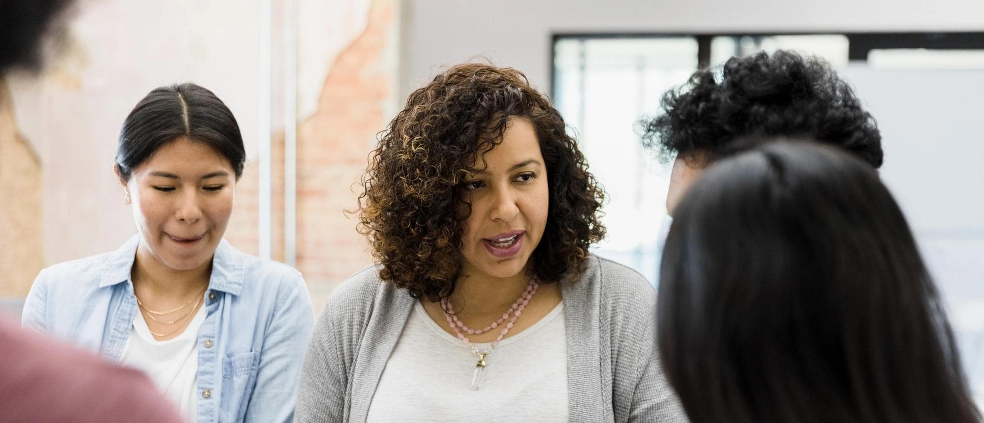 A diverse group of women discuss financial matters with each other.  