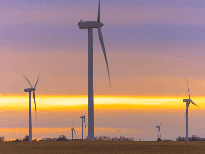 Wind turbines spin at sunrise in Saskatchewan, Canada.