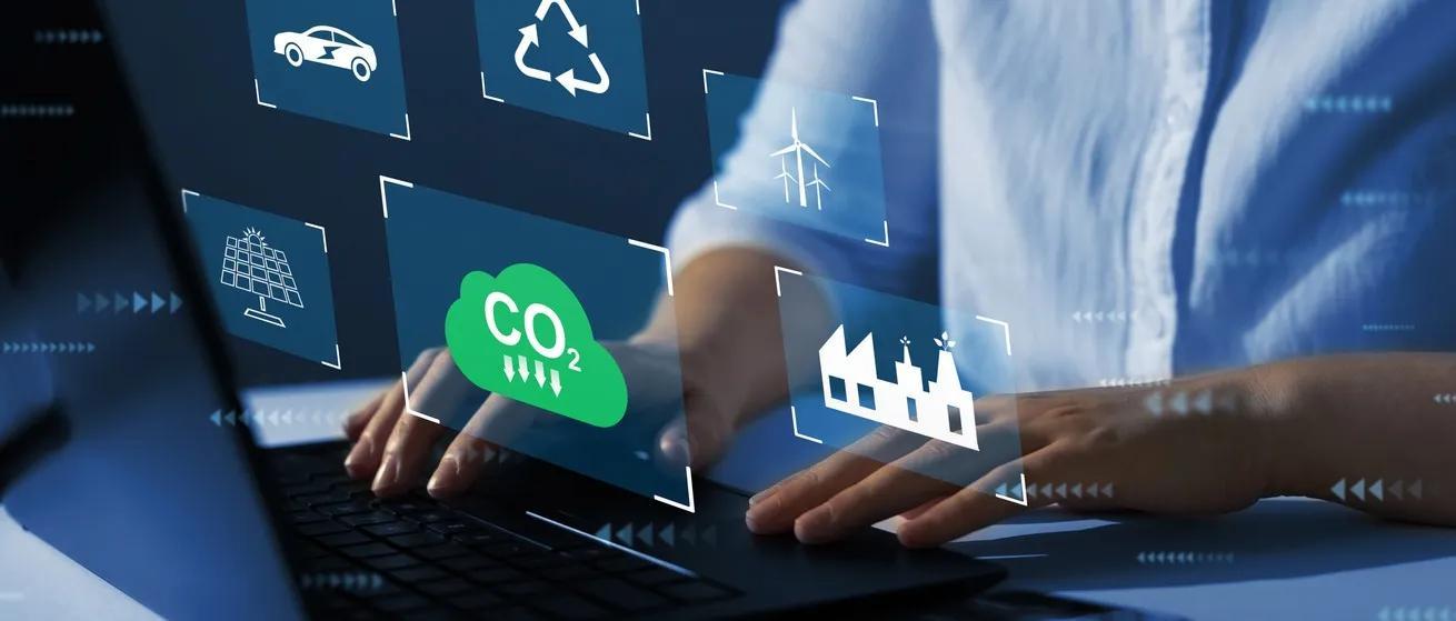 Images representing renewable energy and climate-related data appear above a laptop as a person types. 