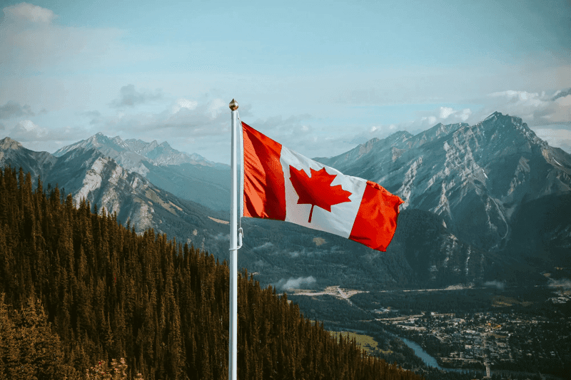 Canadian flag over mountain range 