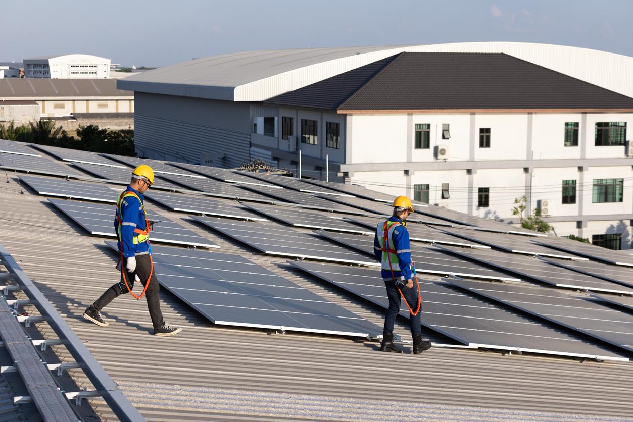 Two engineer walking on rooftop for checking solar panel