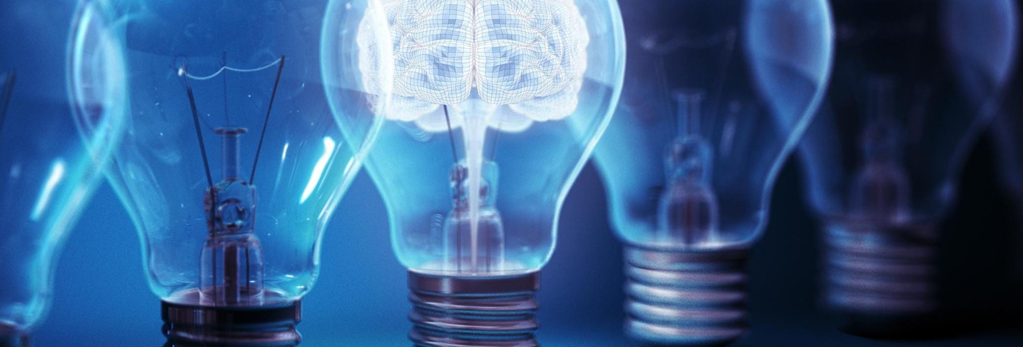 A row of light bulbs with one illuminated with an image of a brain, representing ideas.