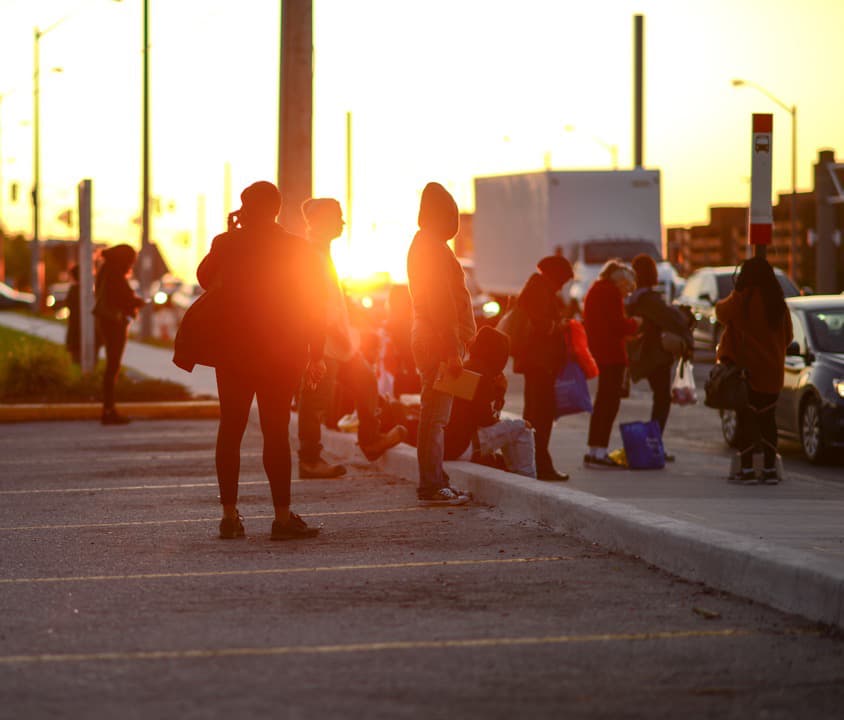 people wait as the sun sets