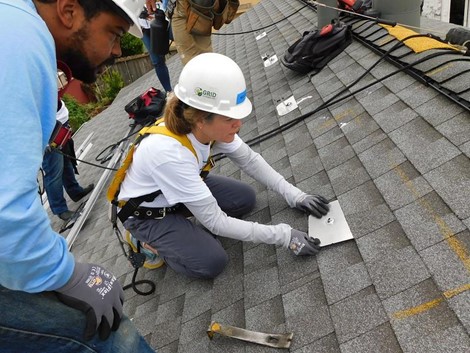 Team installing rooftop solar panels. 