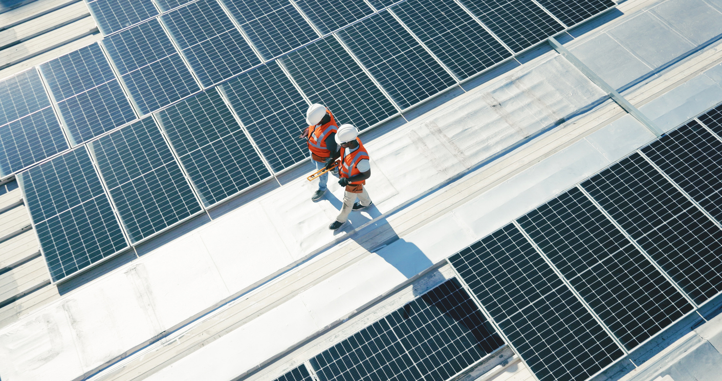 Team inspecting rooptop solar panels in urban setting.