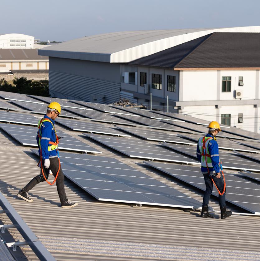 Two engineer walking on rooftop for checking solar panel