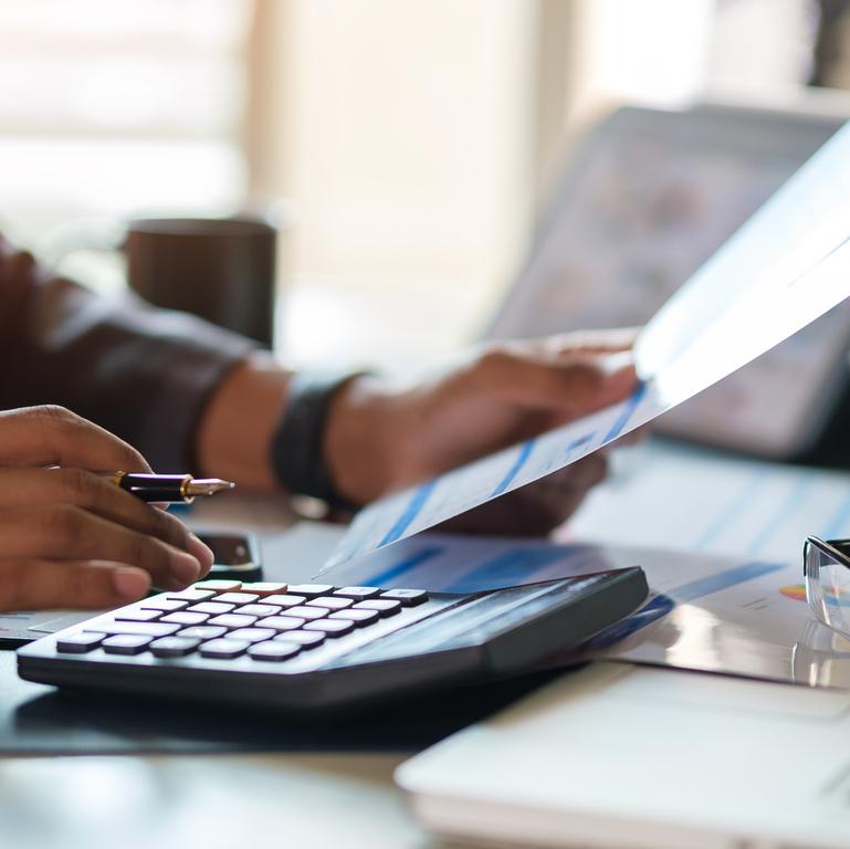 Young man using calculator for refinancing