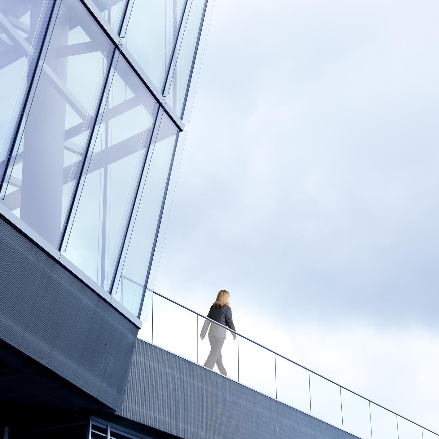 Woman walking along building walkway